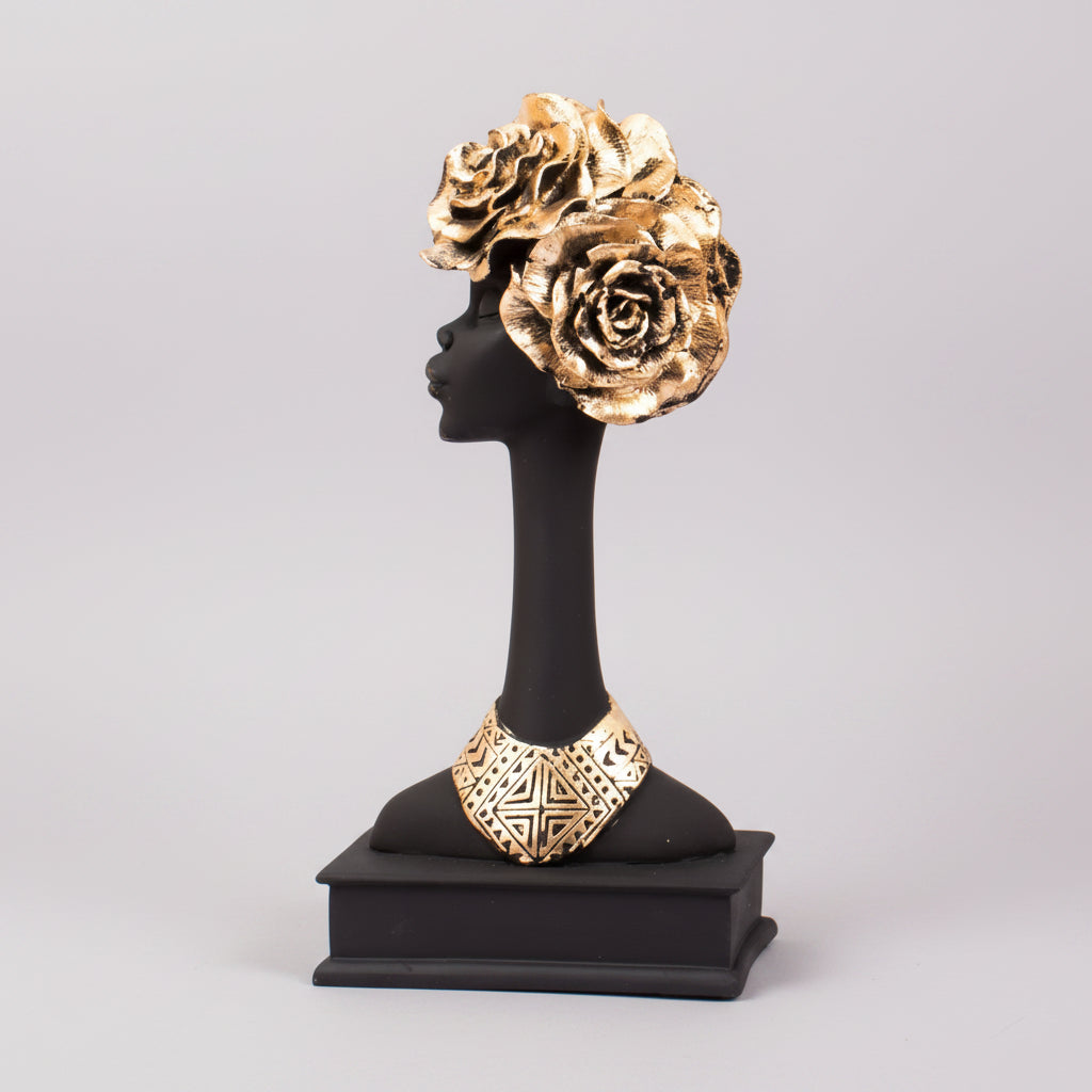 A resin figurine of an African lady with a floral headdress and a necklace, displayed on a black stand.