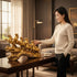 Aurance golden 7 running horses resin statue on a table, with a woman touching the sculpture in a modern living room.