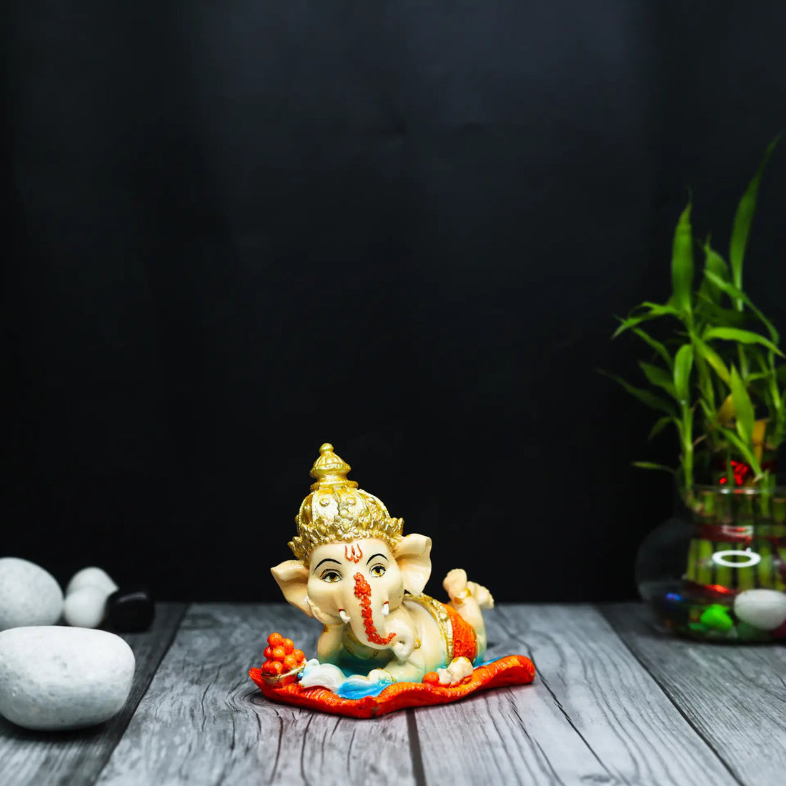 Aurance handcrafted resin Bal Ganesha figurine reading the Ramayana, featuring gold accents on a red mat.