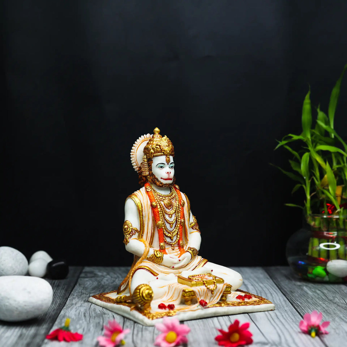 Aurance Lord Hanuman sitting statue in a meditative pose, reading a book with a gada, featuring gold and white detail.