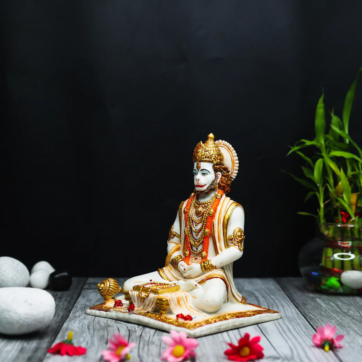 Aurance Lord Hanuman sitting statue in meditative pose, holding a gada and reading a book, with gold accents.
