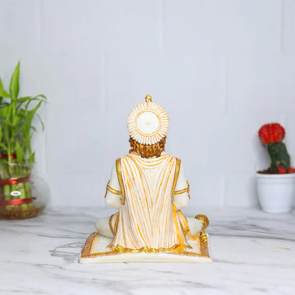 Rear view of an Aurance Lord Hanuman statue in a meditative sitting posture with a gada, set on a marble surface.