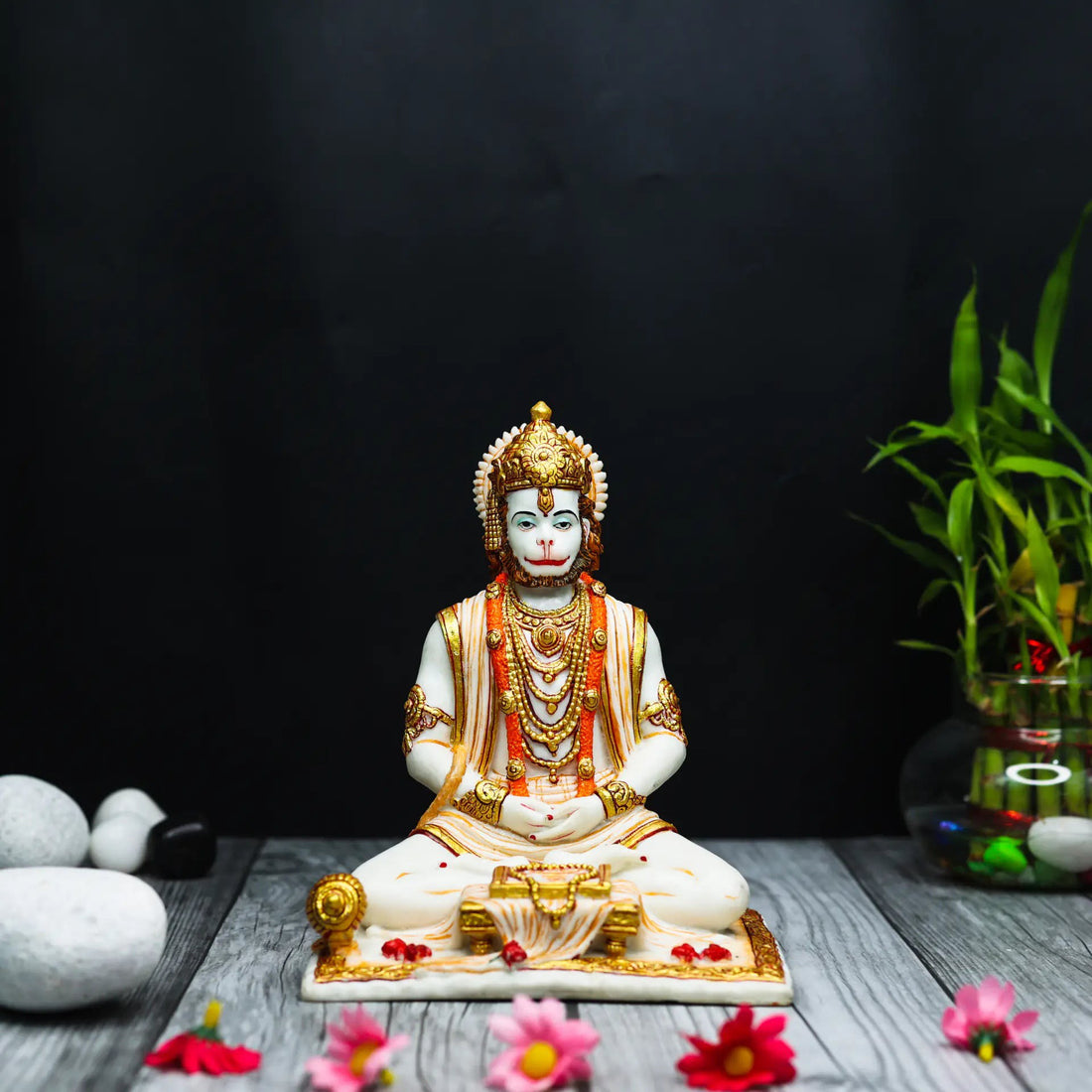 Aurance Lord Hanuman sitting statue in a meditative pose, reading a book with a gada, featuring gold and white detail.