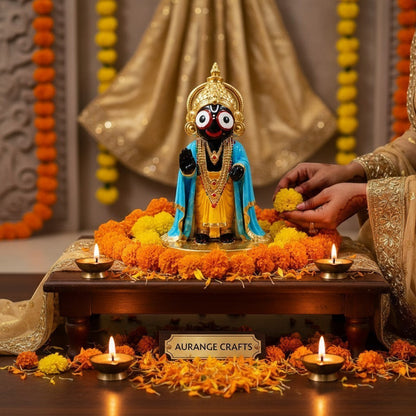 Aurance handcrafted resin Lord Jagannath statue with marble finish, adorned with marigold flowers and lit diyas.