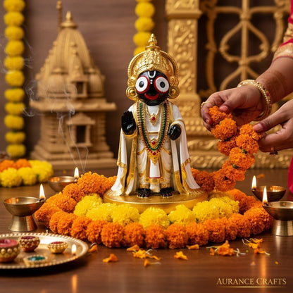 Aurance handcrafted Lord Jagannath resin statue with marble finish, surrounded by marigold flowers and lit oil lamps.
