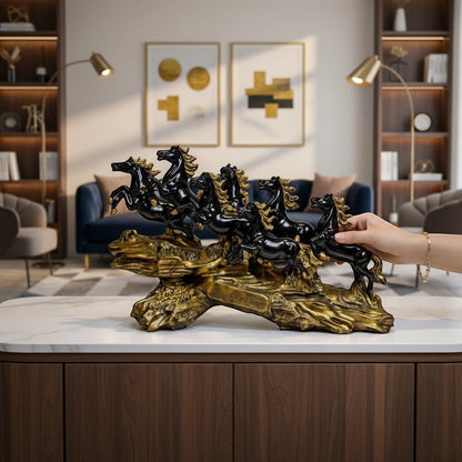 Aurance running horses tabletop sculpture with polished black horses on a textured antique gold base in a living room.